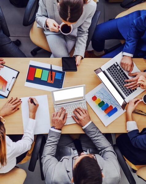 Top view of business people sitting at boardroom and working on important project for big client. Top view of business people sitting at boardroom and working on important project for big client.
